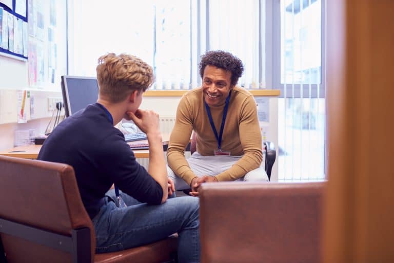 male college student meeting with campus counselor JTEG5YP